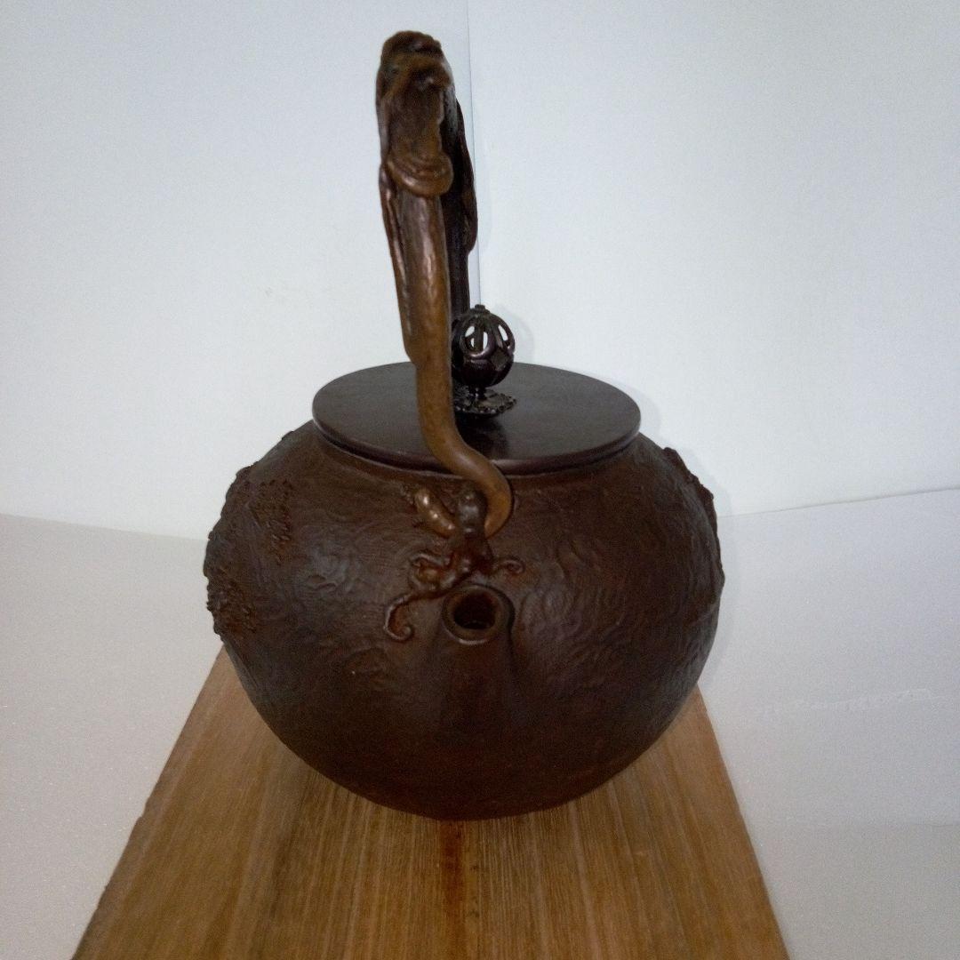 亀文堂造　鉄瓶　楼閣山水盛上紋様　霊芝銅持手